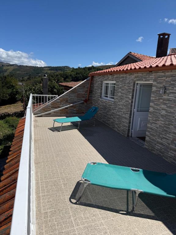 a balcony with a blue bench and a house at Casa de Ferias no Gerês in Ferral