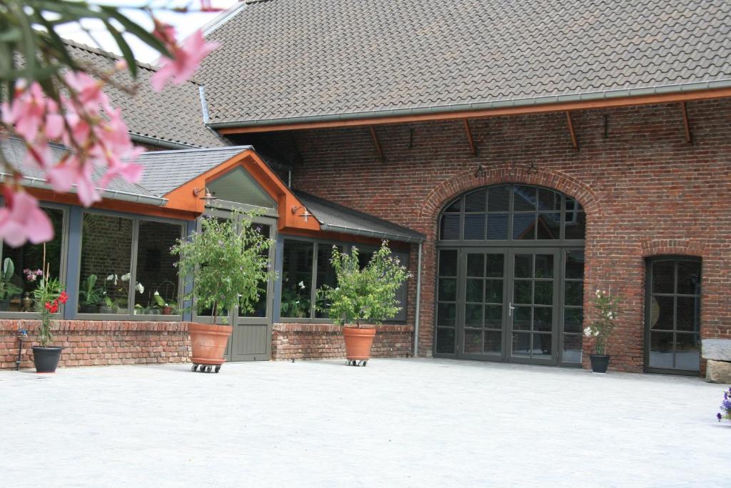 a brick building with potted plants in front of it at Hotel Oude Eycke in Maaseik