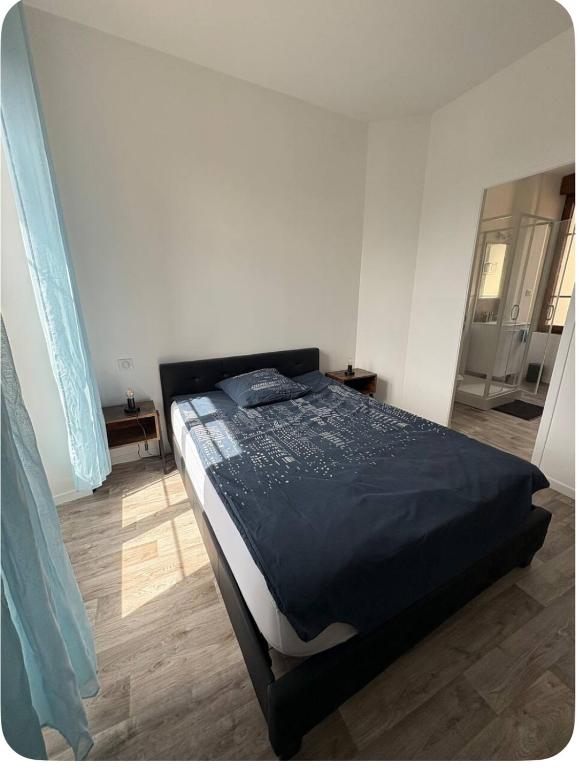 a bedroom with a large bed in a room at Chambre avec salle de bain privé in Neuvic