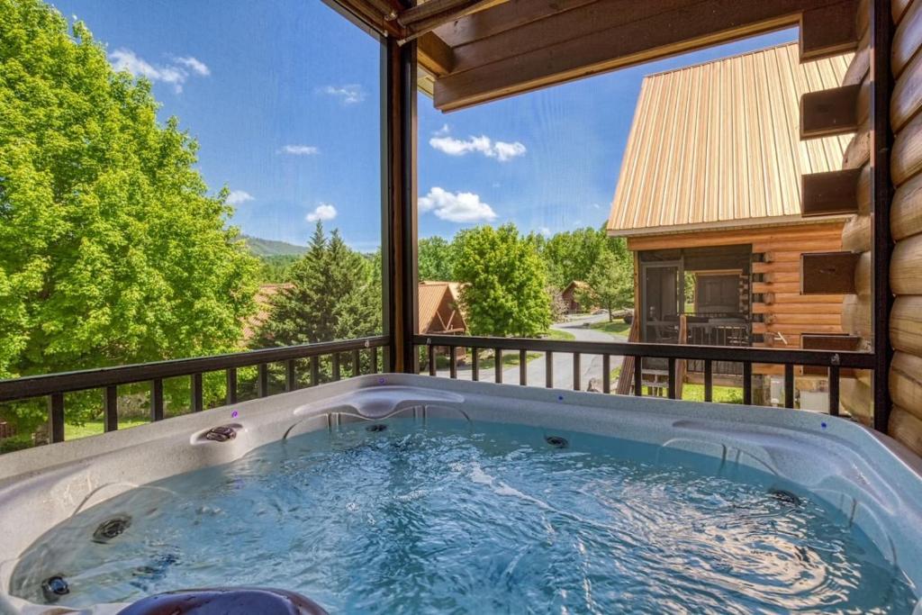 a hot tub on the balcony of a house at Cozy Log Cabin, hot tub, pool table, pool access in Gatlinburg