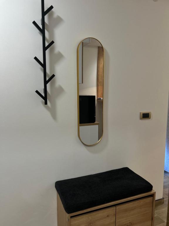 a mirror on a wall next to a wooden table at Apartman Porta 108 in Kruševac