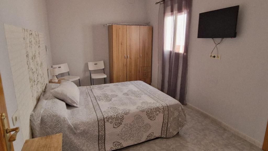 a bedroom with a bed and a television in it at Villa Izael AT-BA-00317 in Talavera la Real