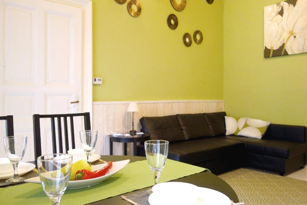 布達佩斯的住宿－熱鬧羅薩公寓，客厅配有沙发和带一碗水果的桌子