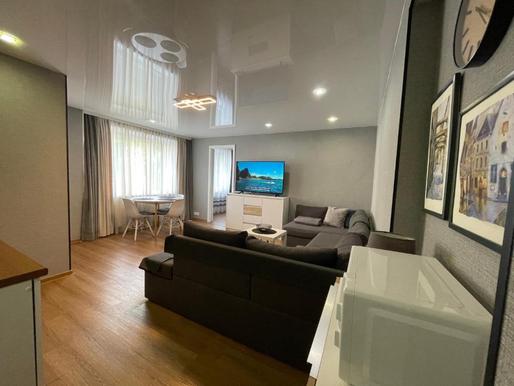 a living room with a couch and a tv at Like a home Linda Apartment in Narva