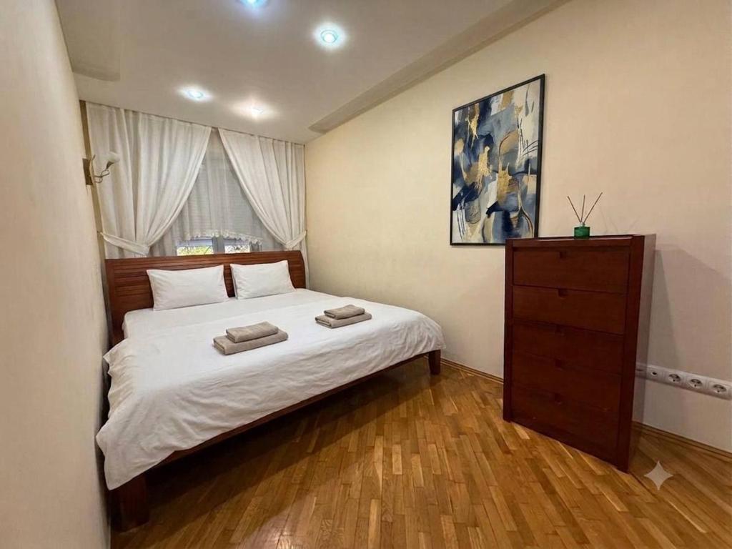 a bedroom with a bed with two towels on it at Центр Пассаж ЦУМ in Dnipro