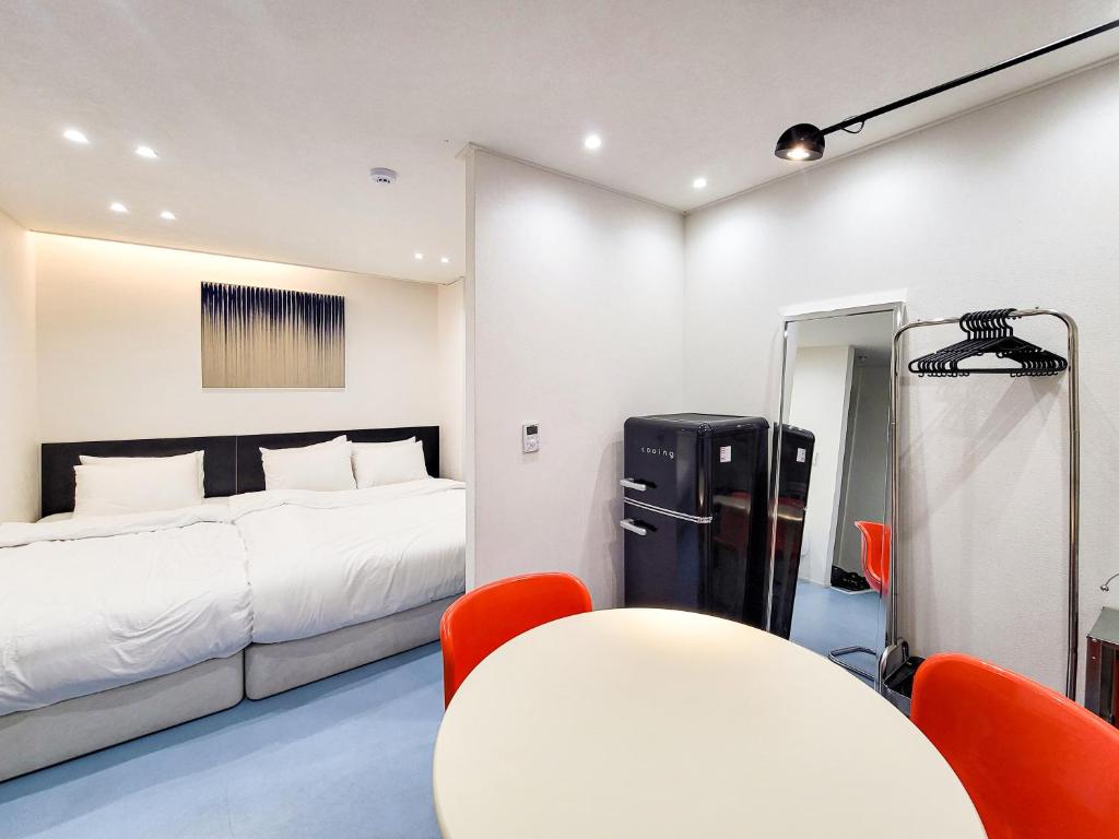 a bedroom with a bed and a table and chairs at 호텔느릿 in Seoul
