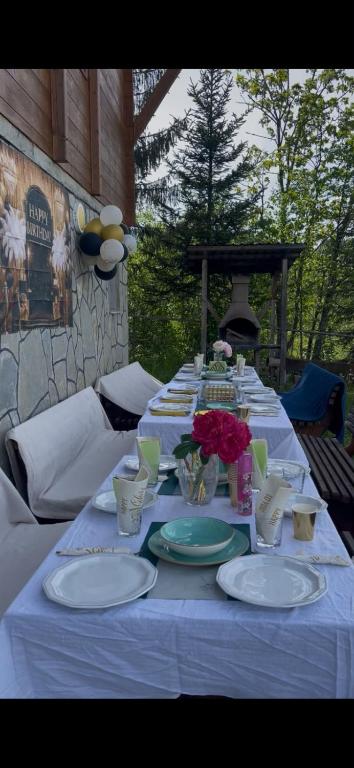 a long table with white plates and flowers on it at Grand house in Rožaje