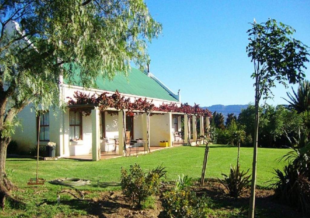 a house with a green roof and a yard at Eikelaan Farm Cottages in Tulbagh