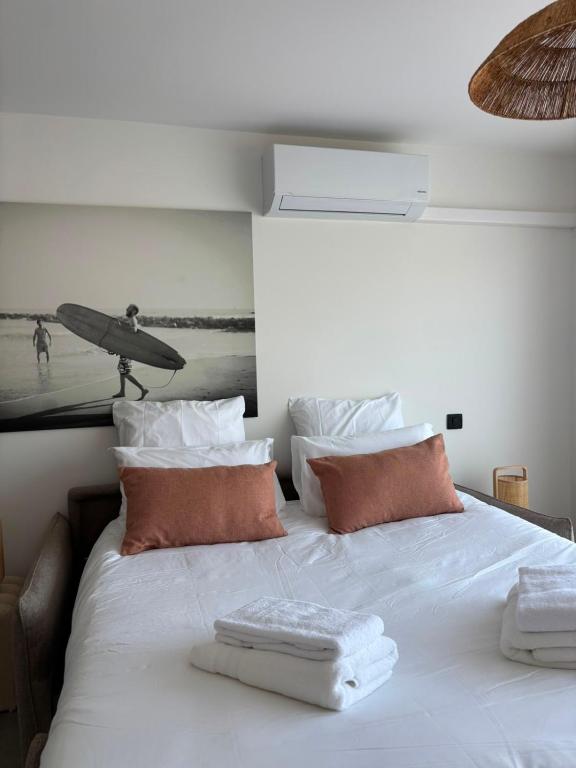 a white bed with two towels on top of it at Villa Lagoon in Carnon-Plage
