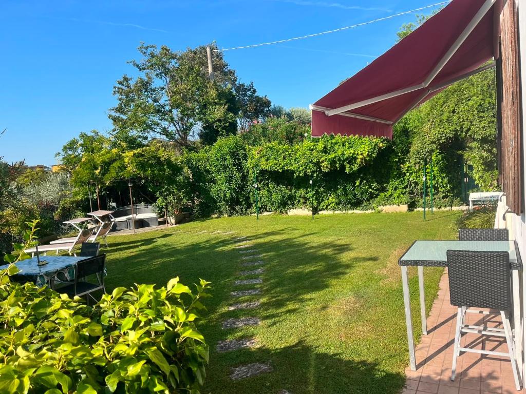 a patio with a table and chairs in a yard at Maison Margherita in Calmasino