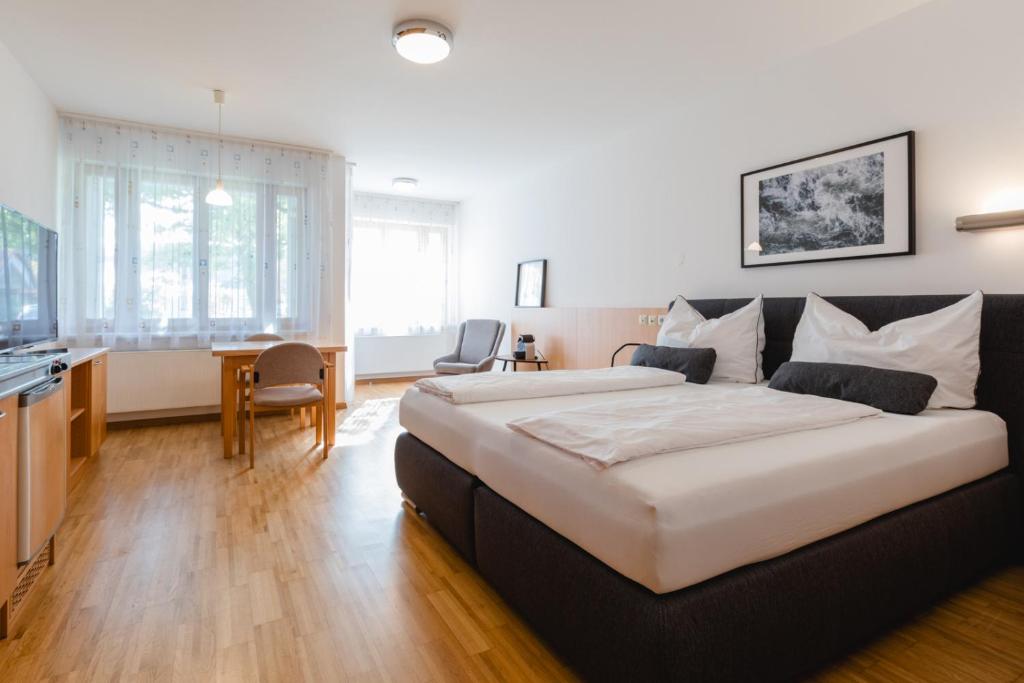 a hotel room with a large bed and a desk at Studiowohnungen am Rieger-Hof in Hartmannsdorf