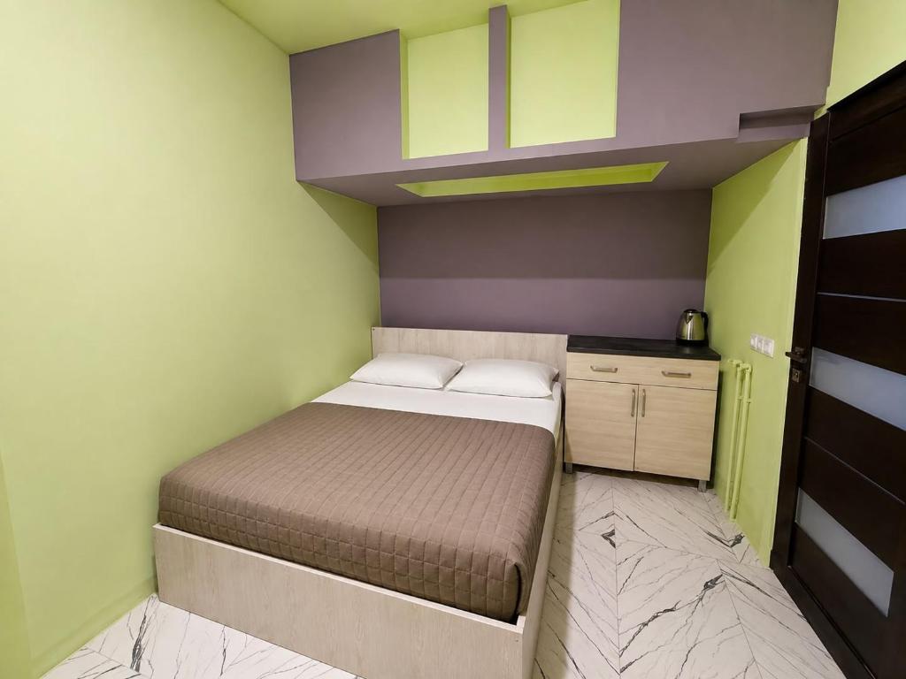 a small bedroom with a bed and a cabinet at Ila Travel Yerevan in Yerevan