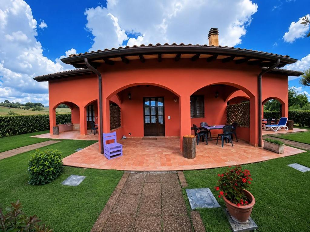 a small orange house with a circular patio at Agriturismo Niccoland in Grosseto