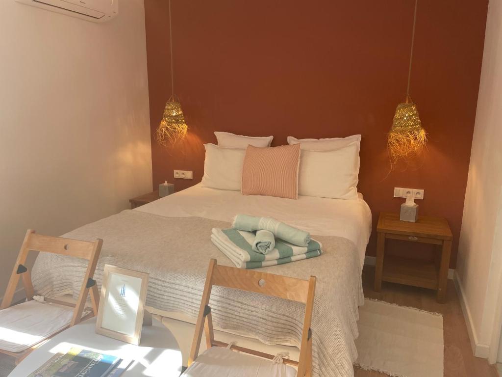 a bedroom with a large bed with two chairs at Le Mas de Caroline in Gargas