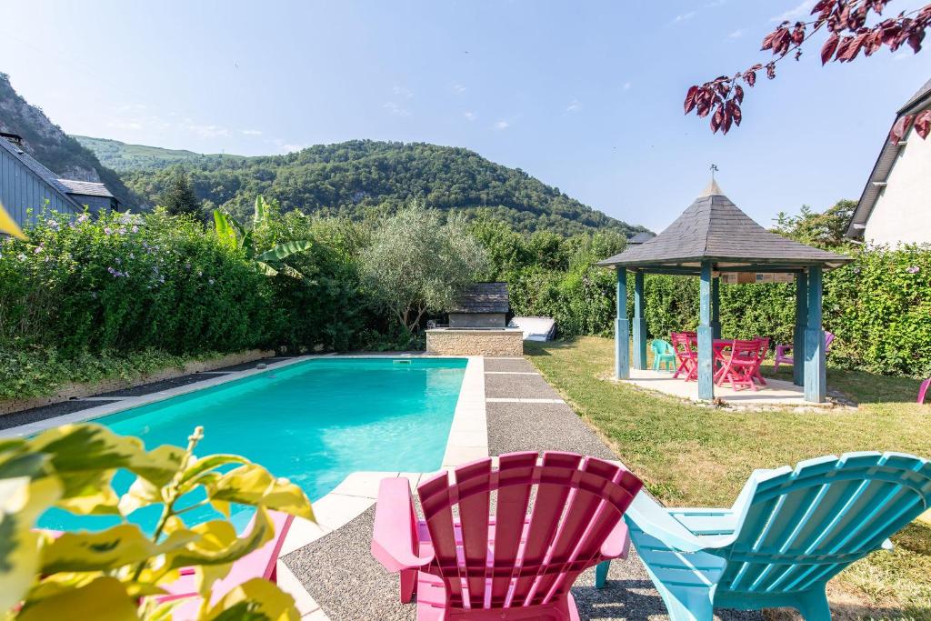a swimming pool with two chairs and a gazebo at Gîte Viscos - L'escapade en famille l Ô Domaine de Geu in Geu