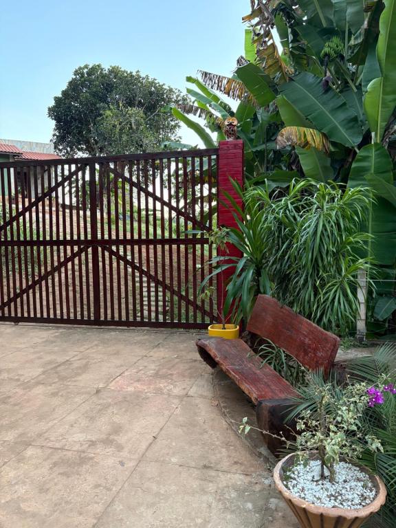 a wooden fence with a bench and some plants at Recanto da Julie in Mulungu