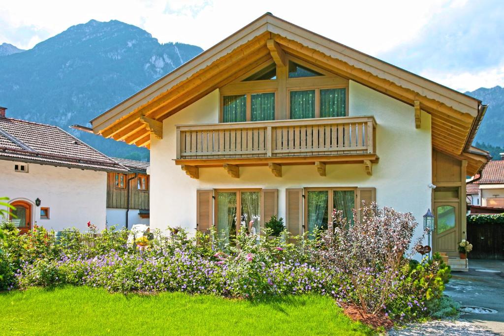 uma casa com uma varanda com montanhas ao fundo em Bergblick em Garmisch-Partenkirchen