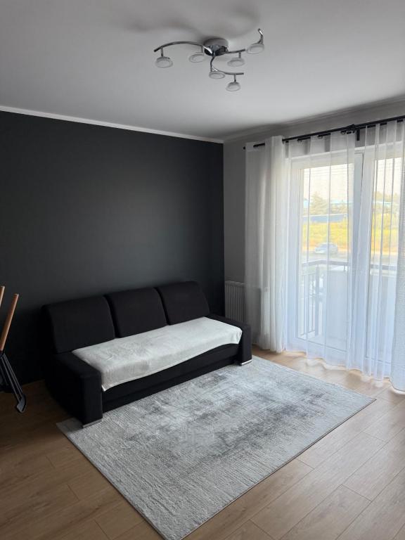 a black bedroom with a bed and a window at Apartament Bald1 in Kąty Wrocławskie