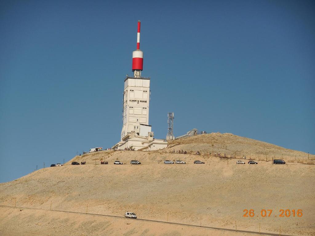 un faro en una colina con coches delante en Les Cigales du Ventoux, en Le Barroux