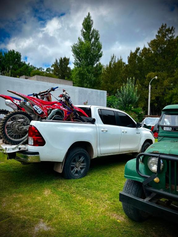 a white truck with motorcycles in the back of it at Tano in Villa Gesell