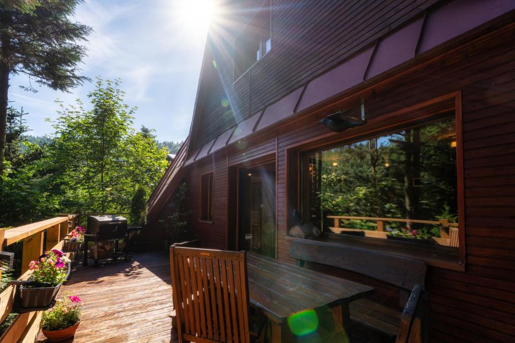 a wooden deck with a table and a window on a house at Ski House Szczyrk - Solisko in Szczyrk
