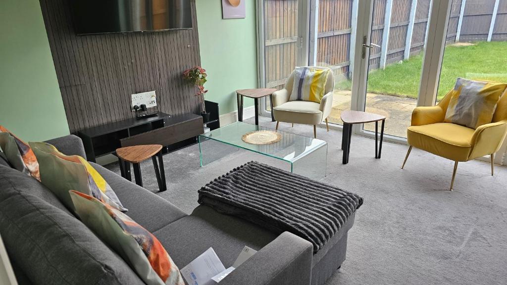 a living room with a couch and chairs at House Sleeps 8 with WiFi in Corby