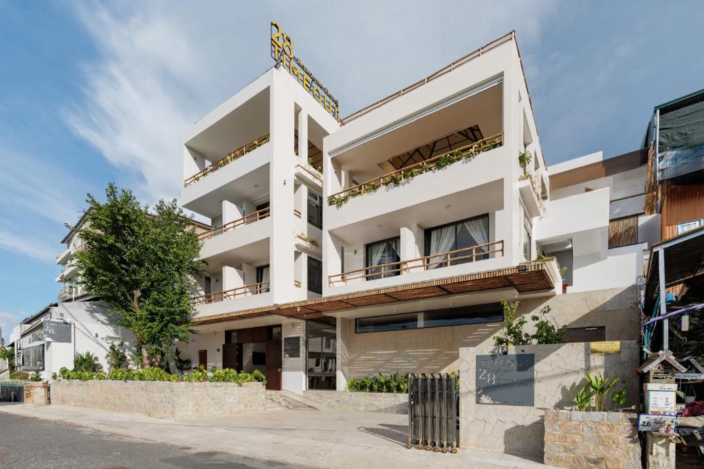 a white building with balconies on a street at TimeOut Dalat Boutique Hotel in Khu Chi Lăng