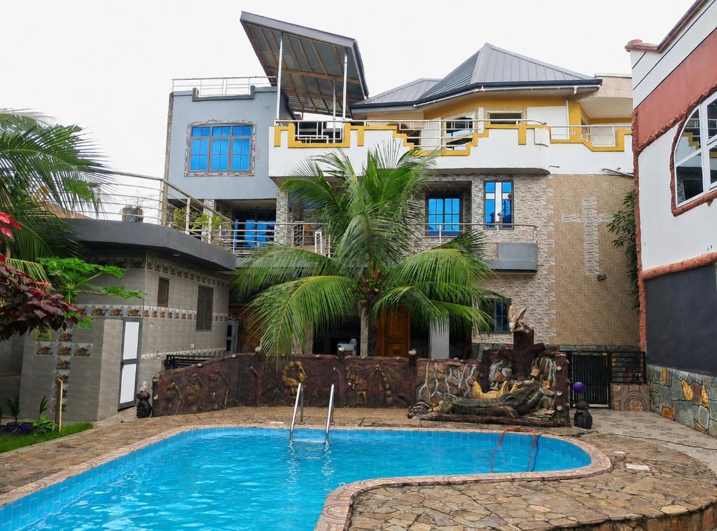 a house with a swimming pool in front of a building at Immanuel Victory Hotel & Restaurant in Ajenkotoku