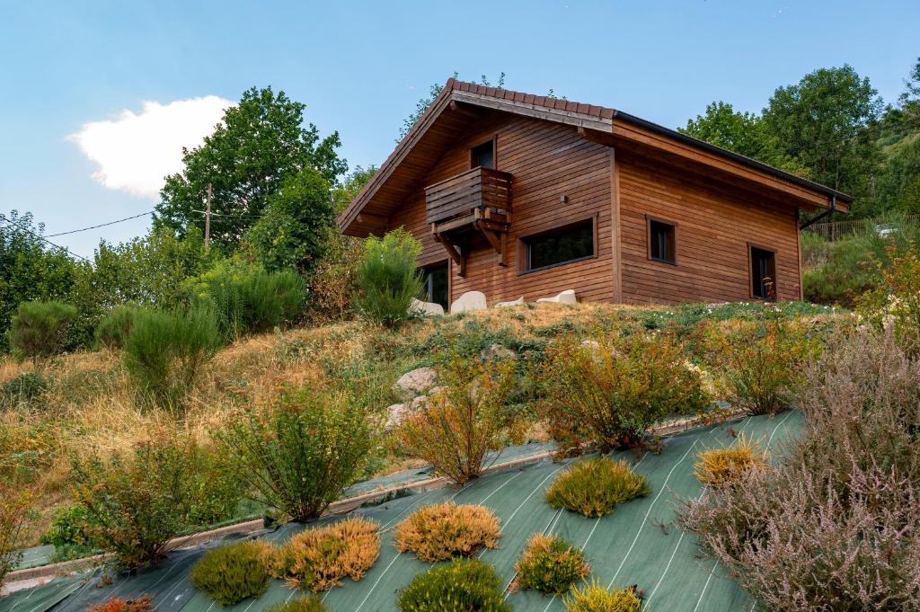 a house on a hill with plants in front at "Les Reflets de la Moselotte" - Chalet premium, calme & confort, vue Montagne, proche Centre et Pistes, Parking in La Bresse
