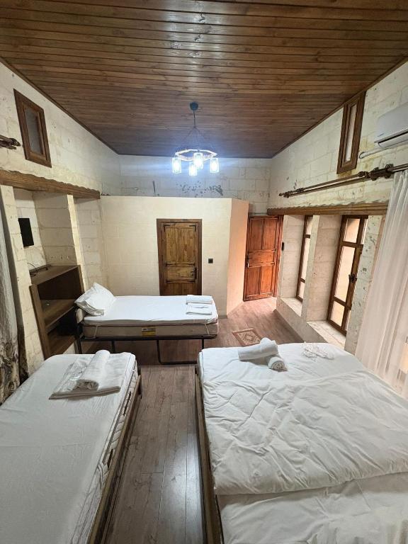 a room with three beds in a room with a ceiling at Ayataç Konak Otel in Urfa
