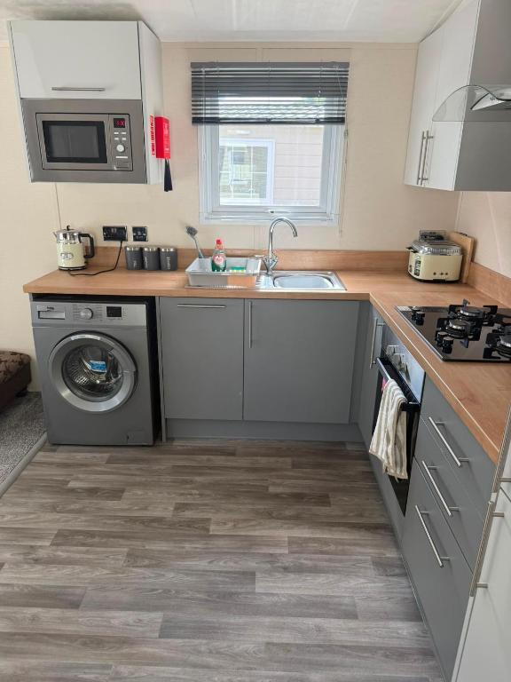 a kitchen with a sink and a washing machine at Static 34 Newton Abbott Devon TQ126JR in Bickington
