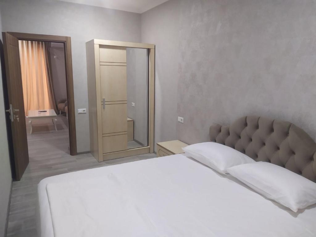 a bedroom with a white bed and a mirror at Alped in Zestafoni