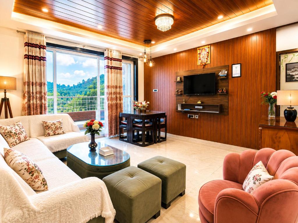 a living room with couches and a television and a table at Rizell Alexis in Shimla
