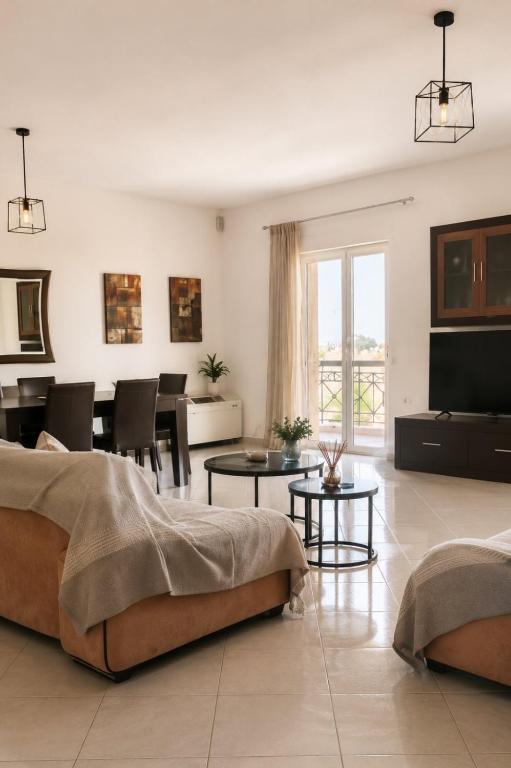 a living room with a bed and a dining room at Among the pines in Katakolo