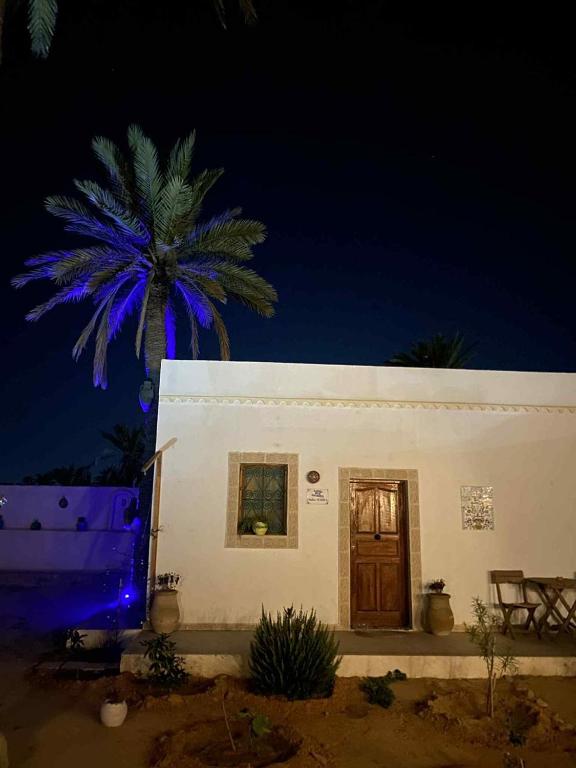 a white house with a palm tree in front of it at La Bohème - Chambres d'hôtes in Midoun