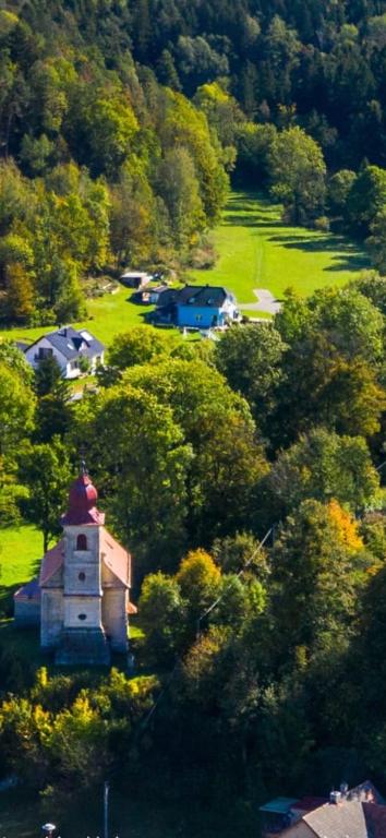 a small building in the middle of a field with trees at KOKOPEPINO in Litomyšl