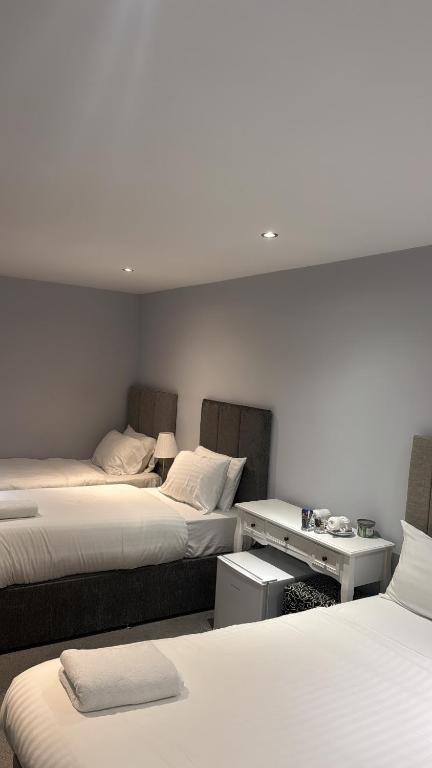 a room with two beds and a desk with two beds at Edinburgh West Residences in Edinburgh