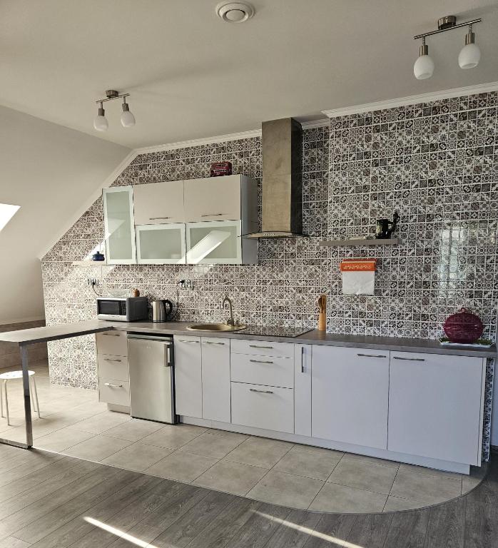 a kitchen with white cabinets and a brick wall at Borowy Zielnik 