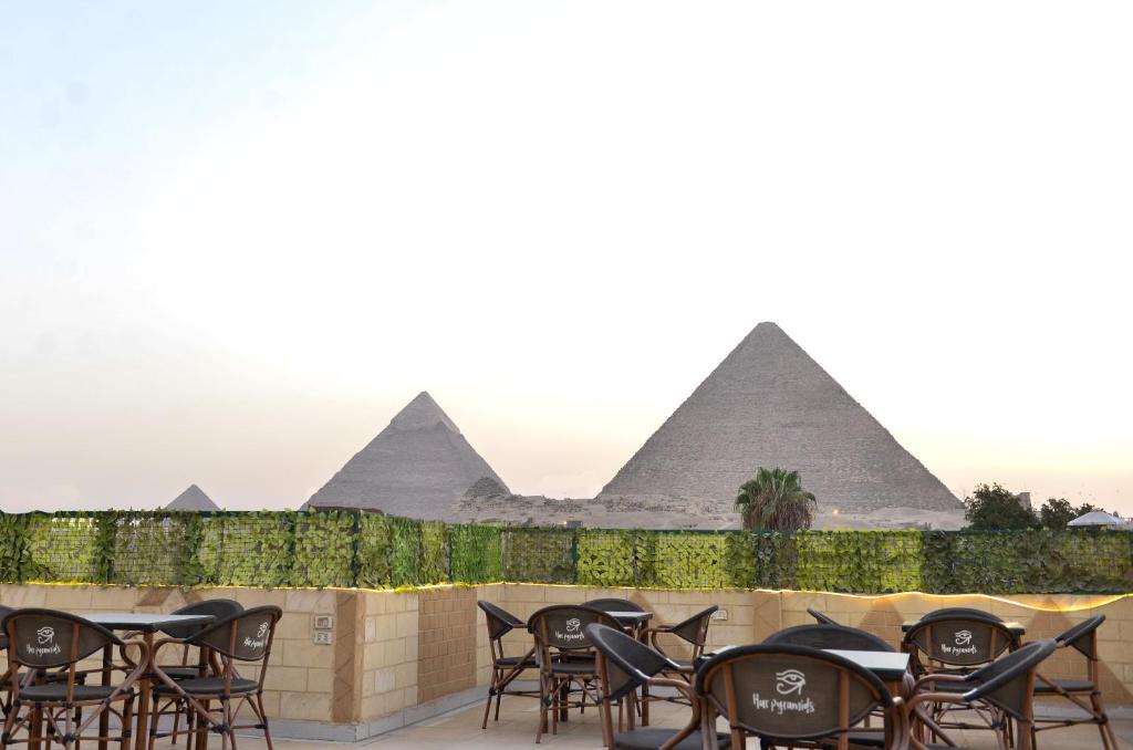 a row of tables and chairs in front of the pyramids at Hur palace pyramids view in Cairo