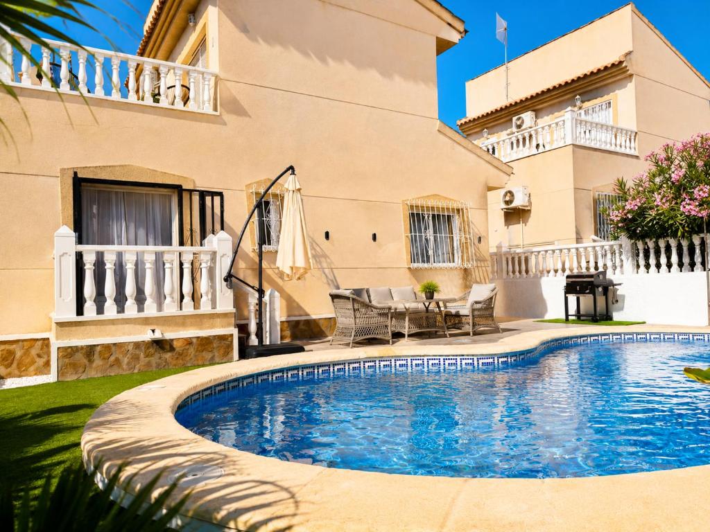 a swimming pool in front of a house at Villa Emika with private pool in Ciudad Quesada in Ciudad Quesada