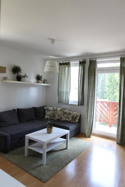 a living room with a blue couch and a table at Apartmán PT Donovaly in Donovaly