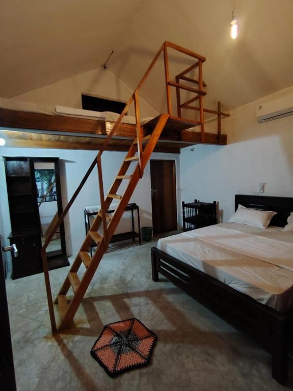 a bedroom with a wooden bunk bed with a ladder at Eco Palms in Pottuvil