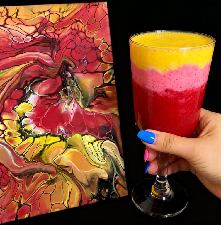 a person holding a drink in front of a painting at Art Studio BN - Create Your Own Fluid ART Masterpiece! in Bistriţa