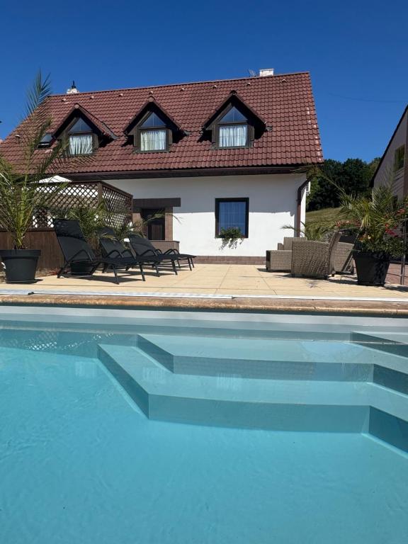 a house and a swimming pool in front of a house at Apart Samont in Velký Ořechov
