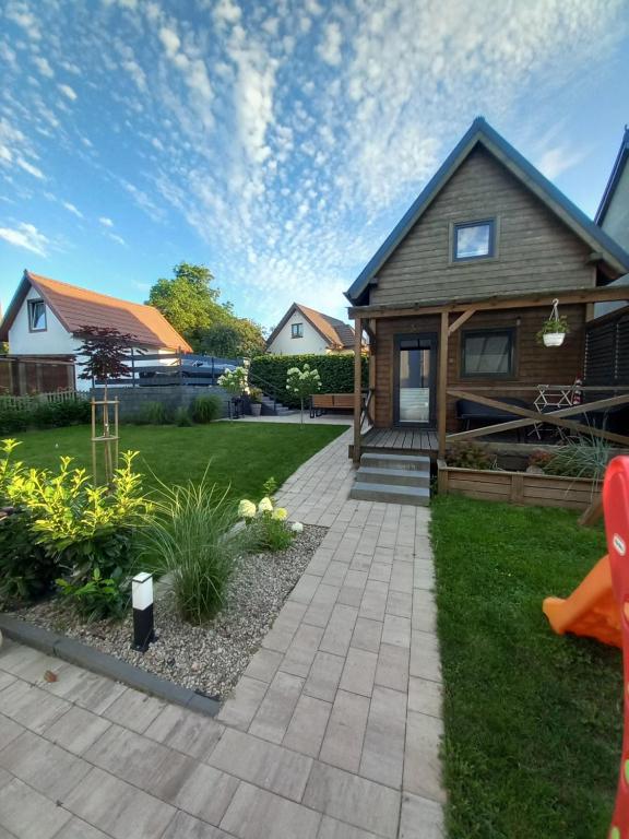 a house with a walkway in front of a yard at Amelia Domek letniskowy in Mechelinki