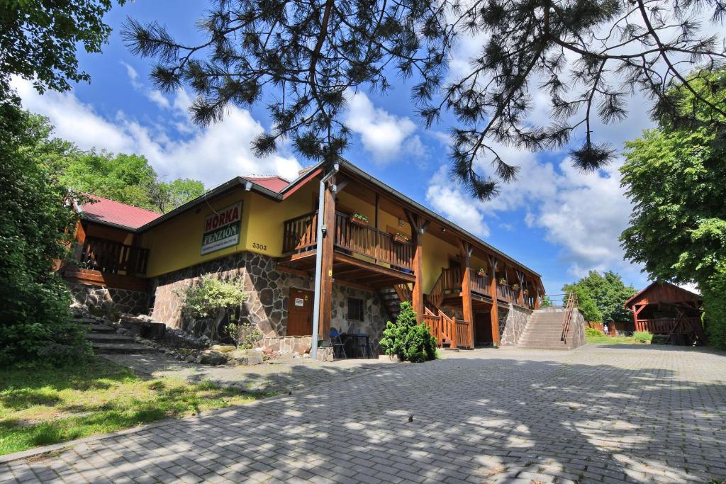 a large yellow building with a porch at Penzión Hôrka in Vinné