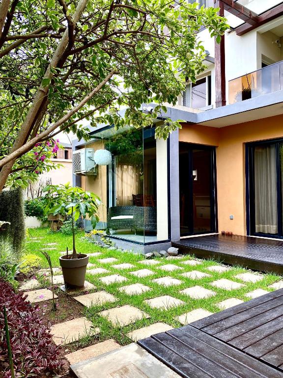 a house with a garden with a walkway in front of it at Sunny Suites Madagascar in Antananarivo