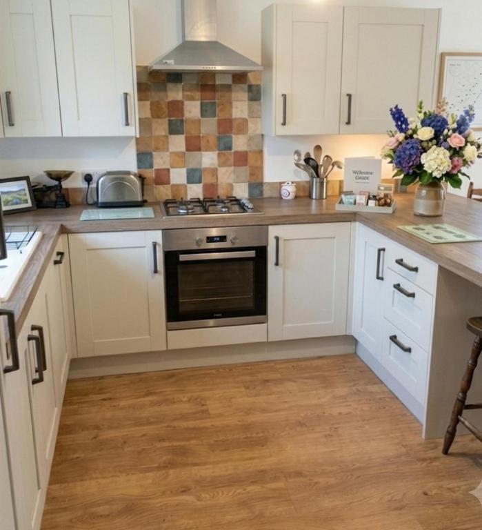 a kitchen with white cabinets and a stove top oven at Sammy's place in Hayle