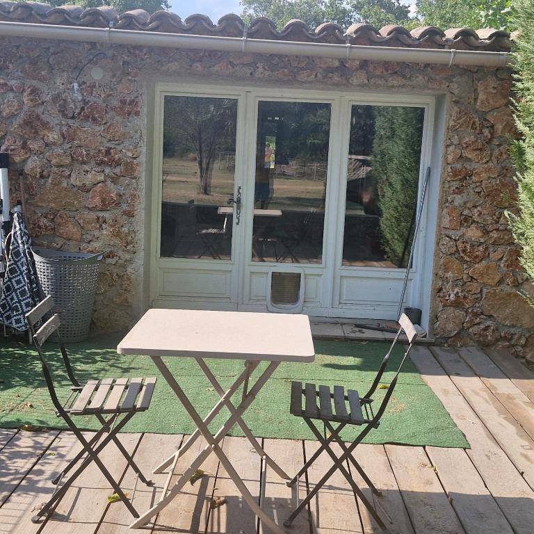 a picnic table and two chairs in front of a door at Pollart in Les Arcs sur Argens