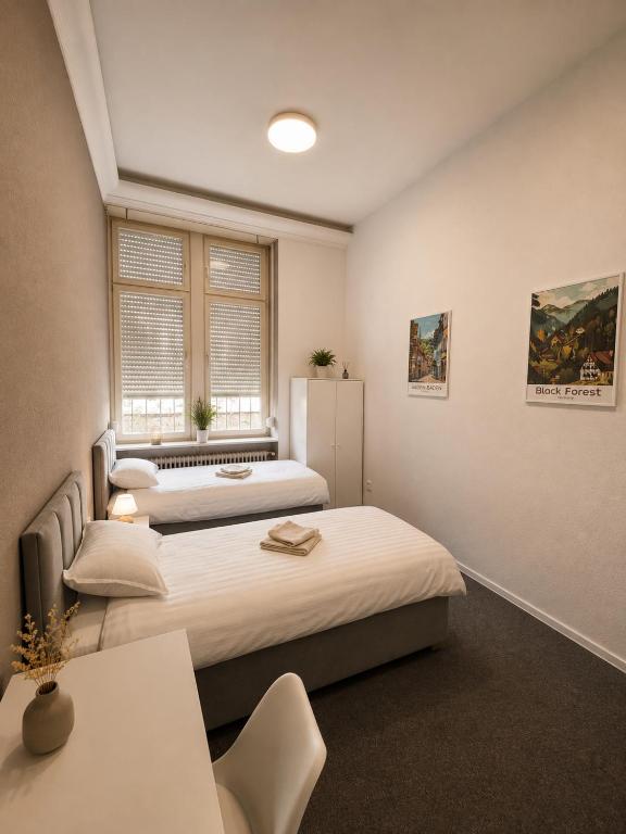 a bedroom with two beds and a window at Ermar Gästehaus in Baden-Baden